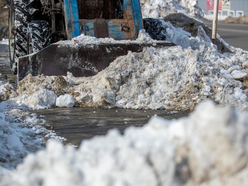 Räumfahrzeug schiebt Schnee von einem Gehweg beim Winterdienst in Bruchsal