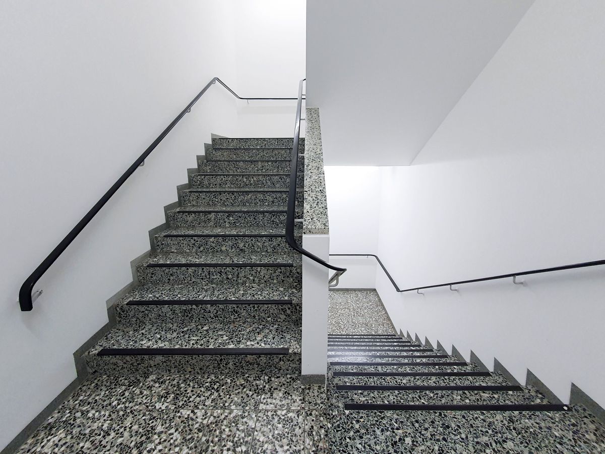 Freies Treppenhaus mit Steinstufen und Handlauf in einer Wohnanlage in Bruchsal