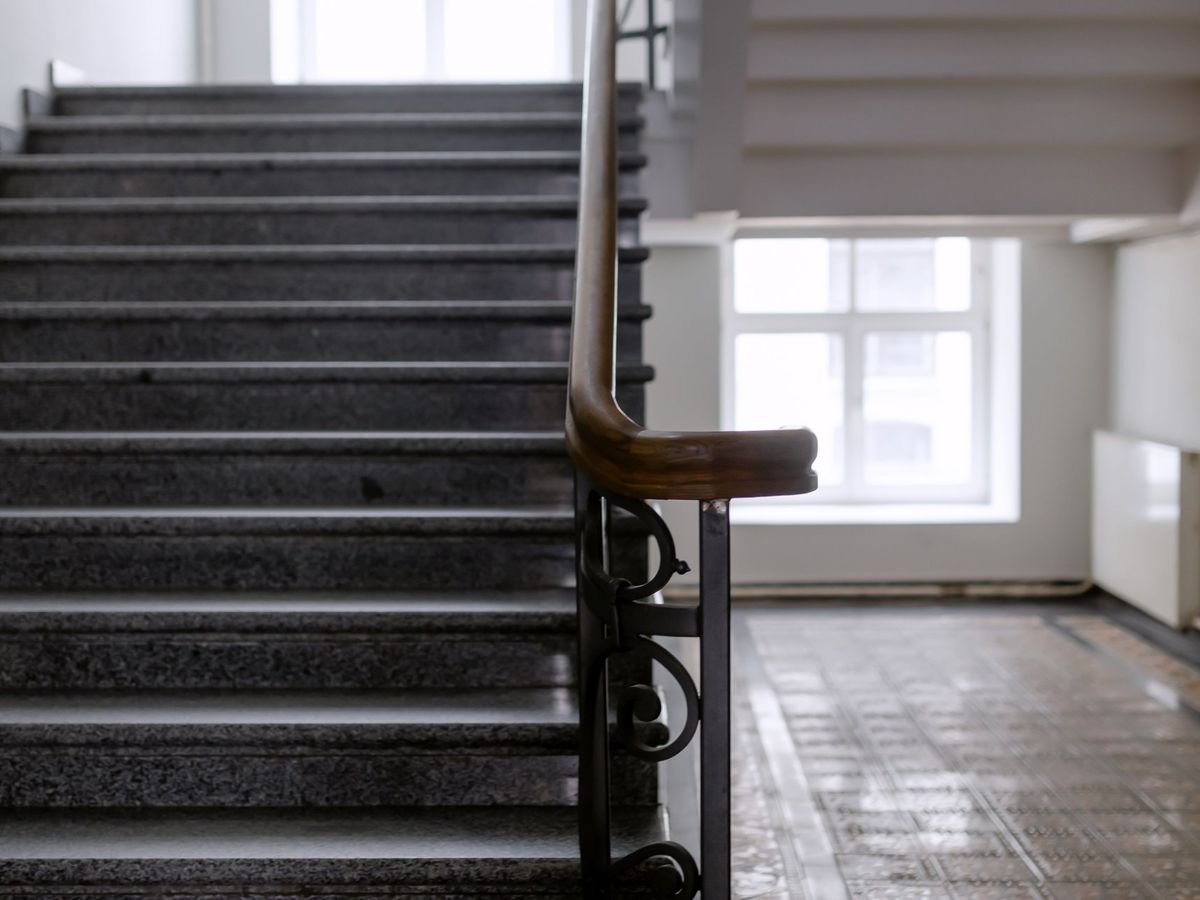 Gereinigtes Treppenhaus mit Steinstufen und Holzhandlauf in einem Mehrfamilienhaus in Bruchsal